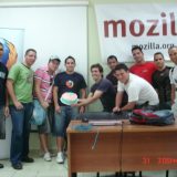 Todos juntos listos para picar los cake al lado del poster